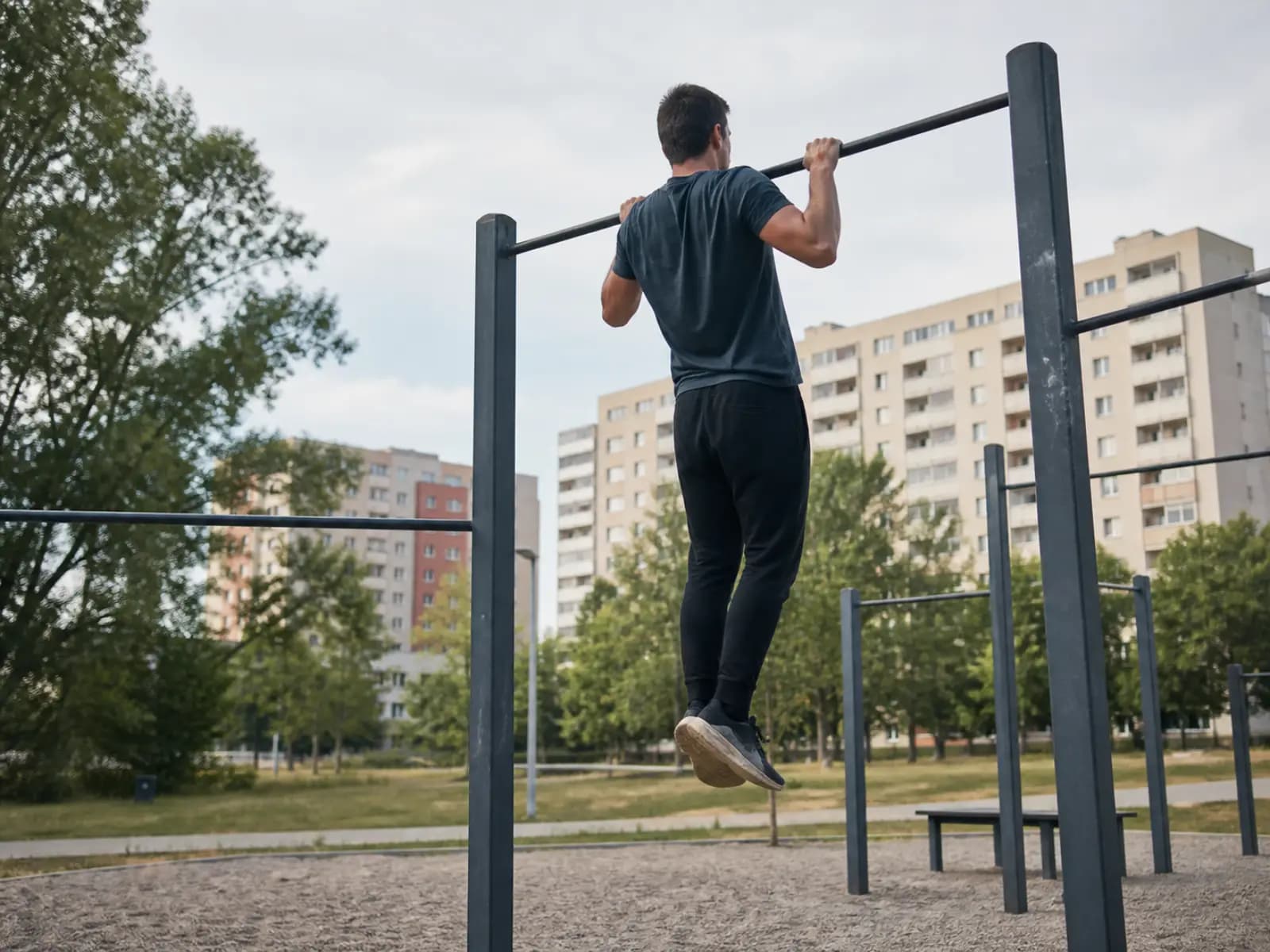 Osoba podciąga się na drążku w parku street workout